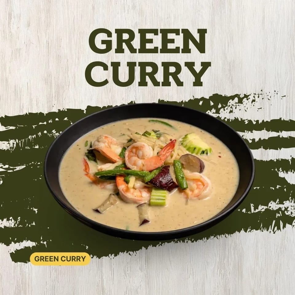 Creamy green curry with shrimp, green beans, zucchini, and eggplant in a black bowl.